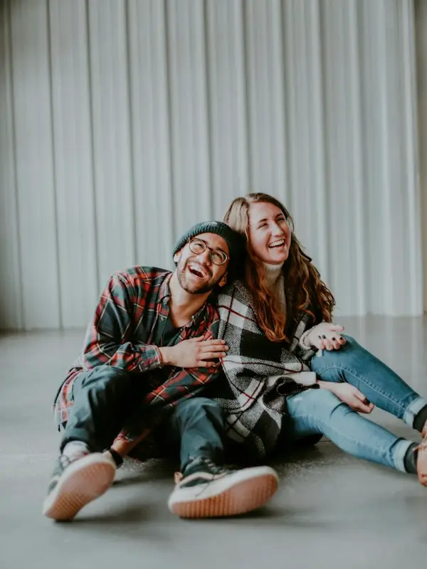 A couple sitting on the floor, laughing