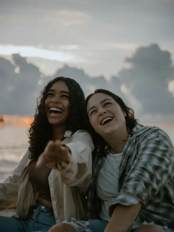 Two friends laughing on a beach