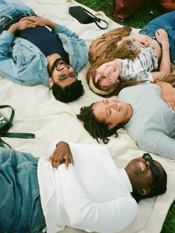Friends lying on a picnic blanket, laughing
